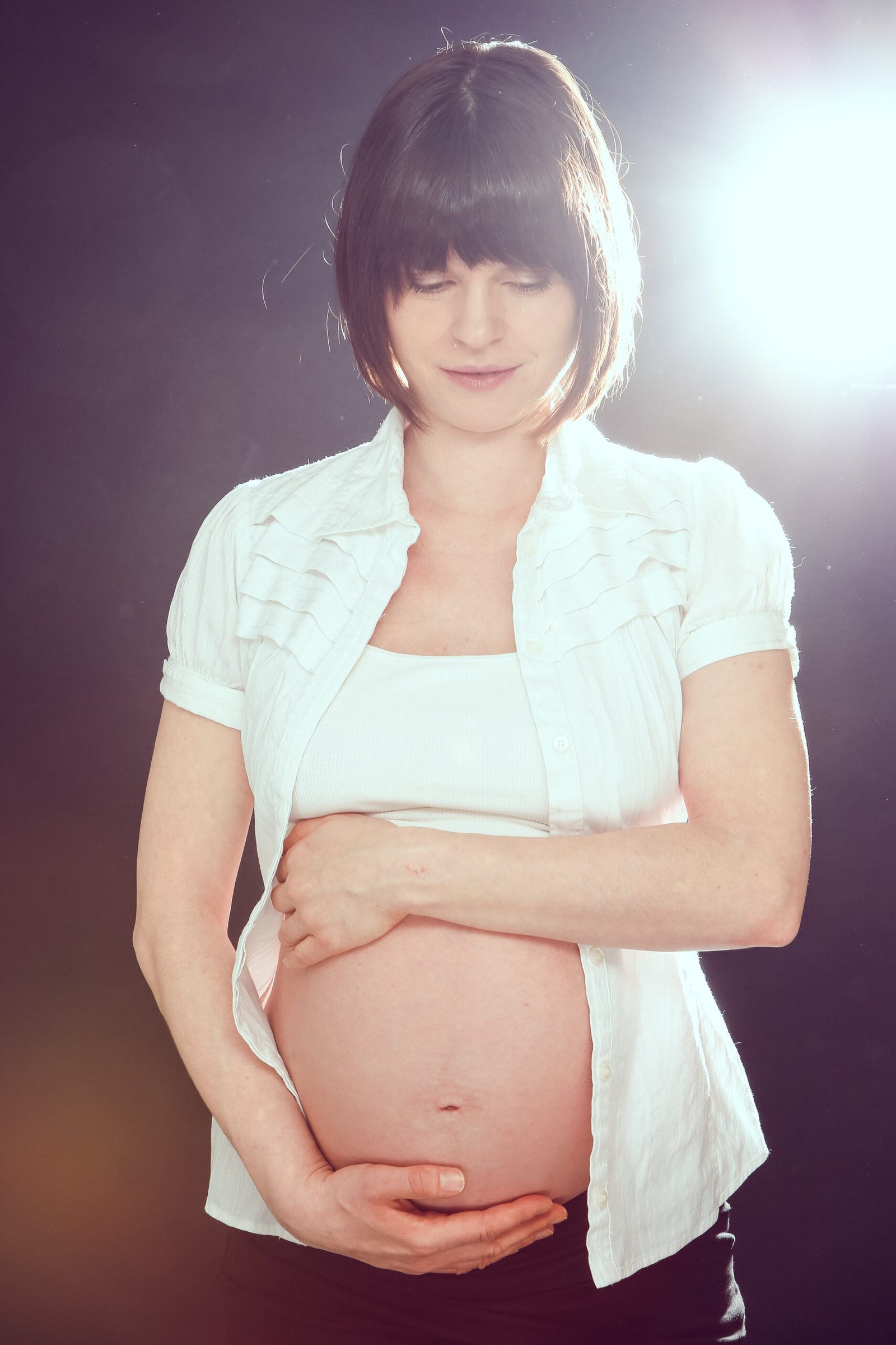 Regina in der 37. Schwangerschaftswoche hält liebevoll ihren Babybauch - Doula mit persönlicher Geburtserfahrung